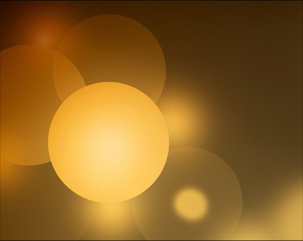 Photo of yellow orbs of various density. One has a focal point